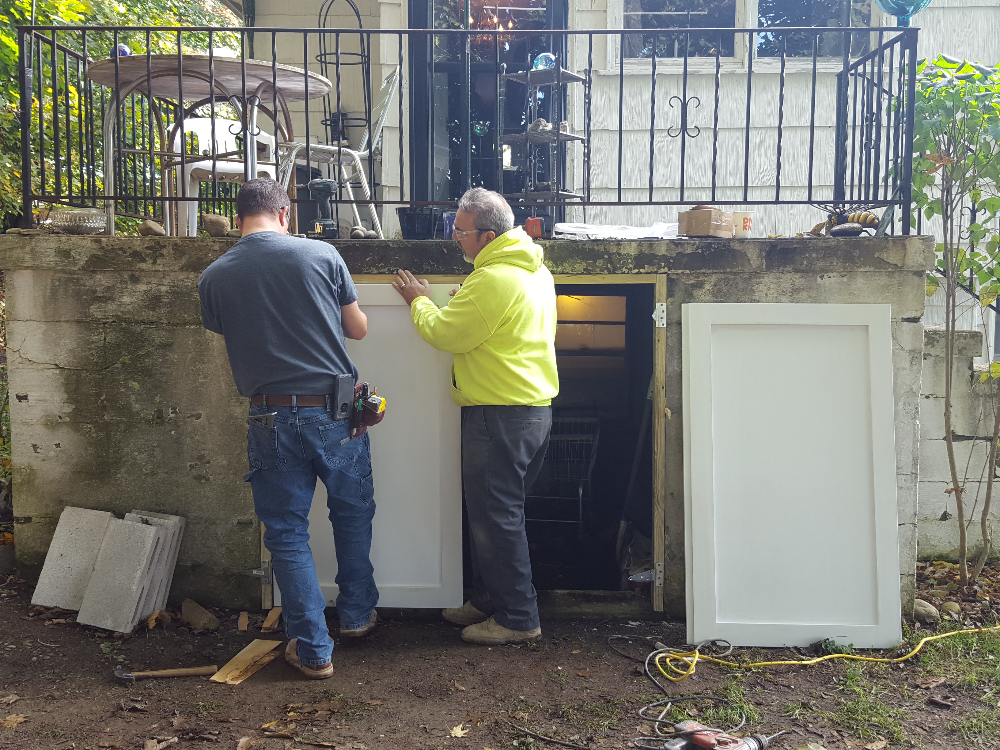 Consigli volunteers work on a door at Michele's home.