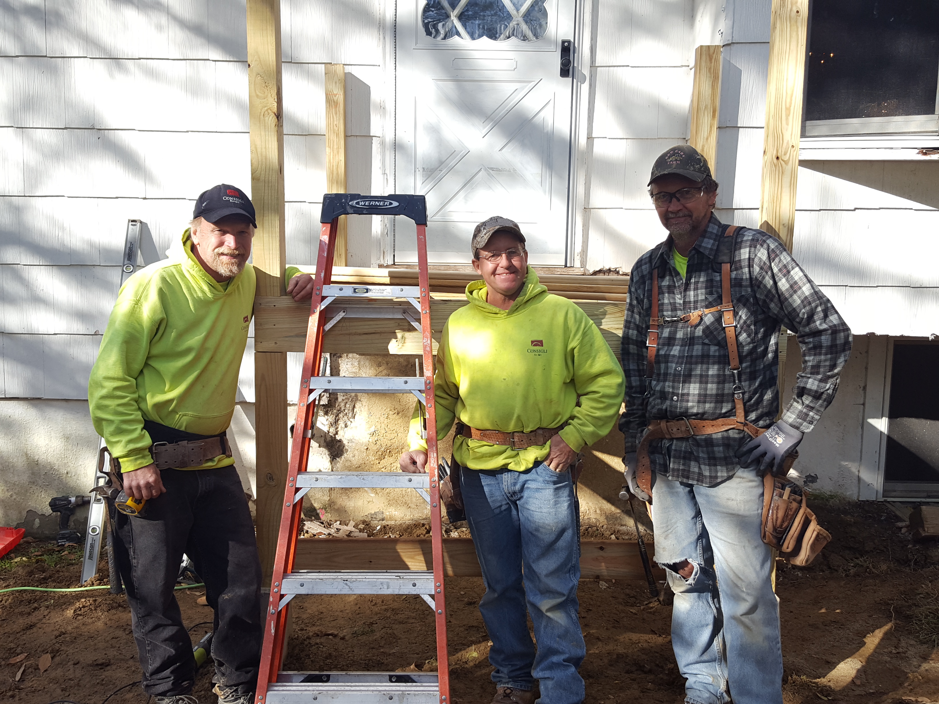 Consigli volunteers take a break in front of Michele's new front landing.