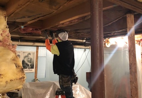 Volunteer repairing the basement ceiling