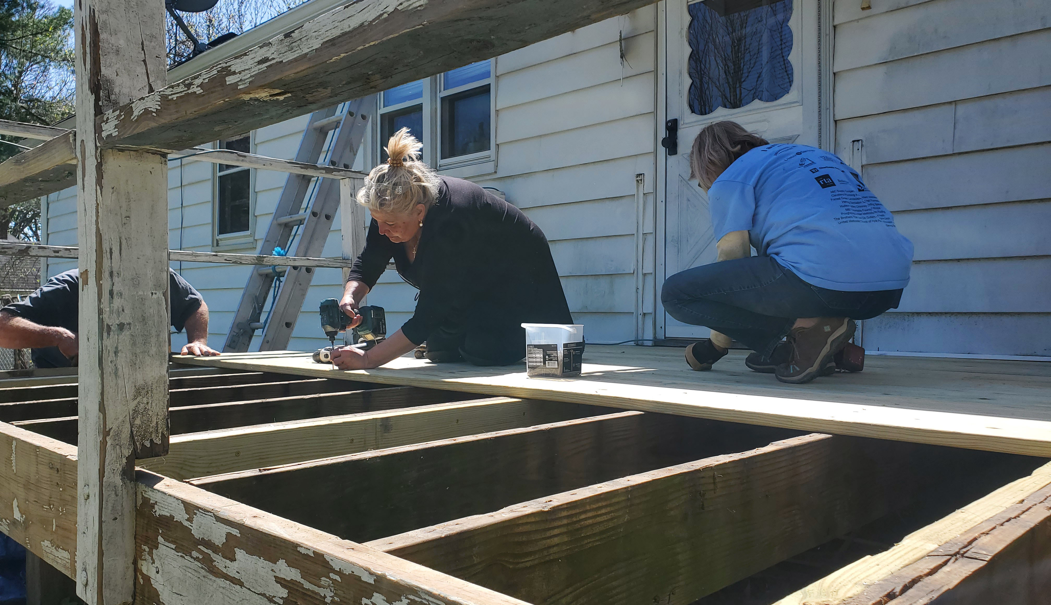 Volunteers working on back deck in need of major repairs