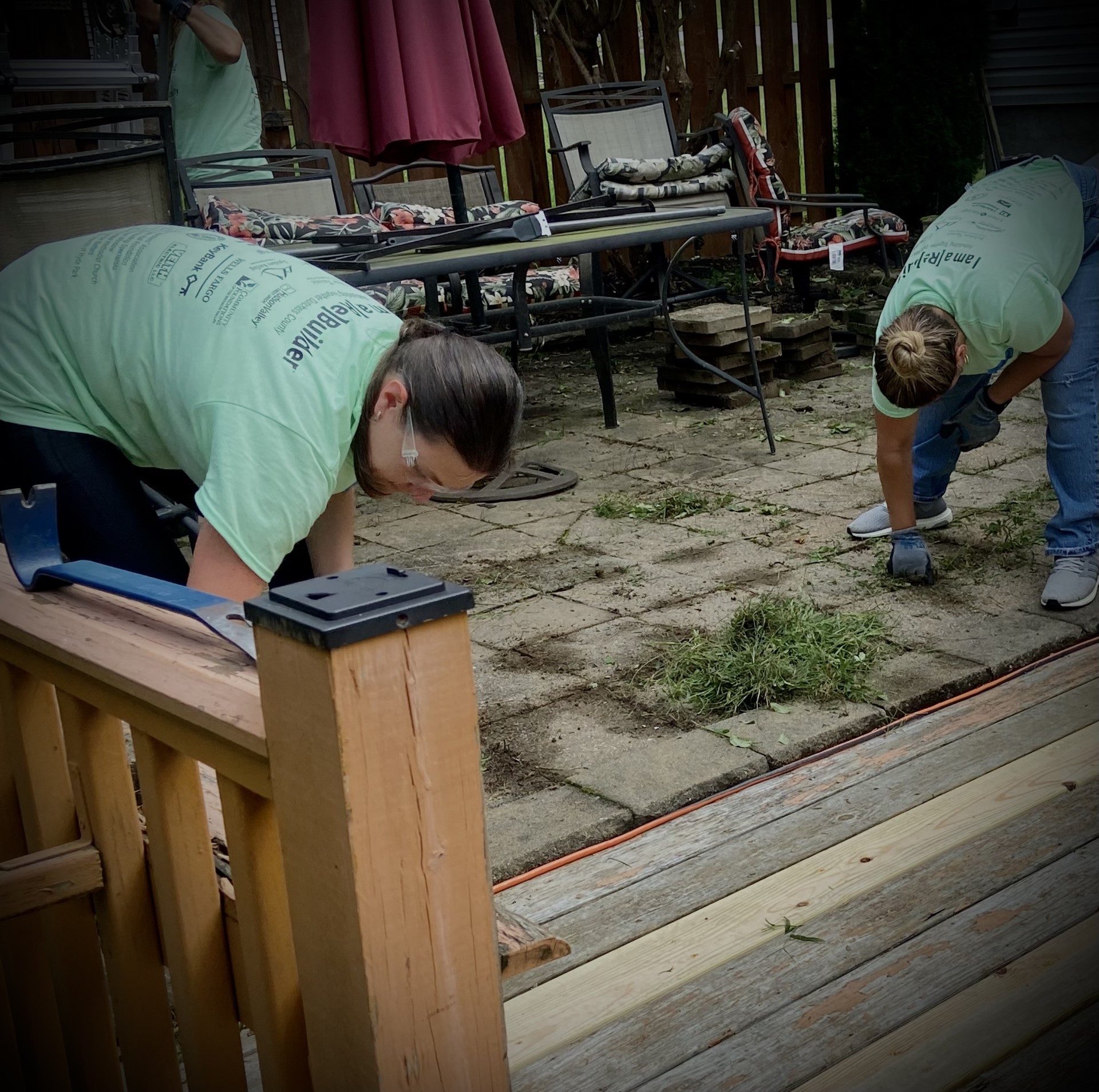 Volunteers work on landscaping pavers at Gloria's home.