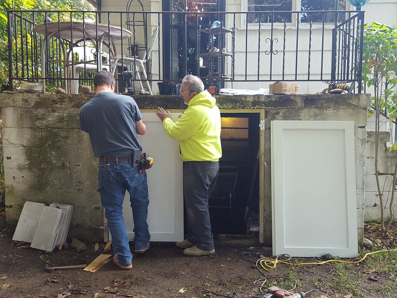 Consigli volunteers repairing a porch door.