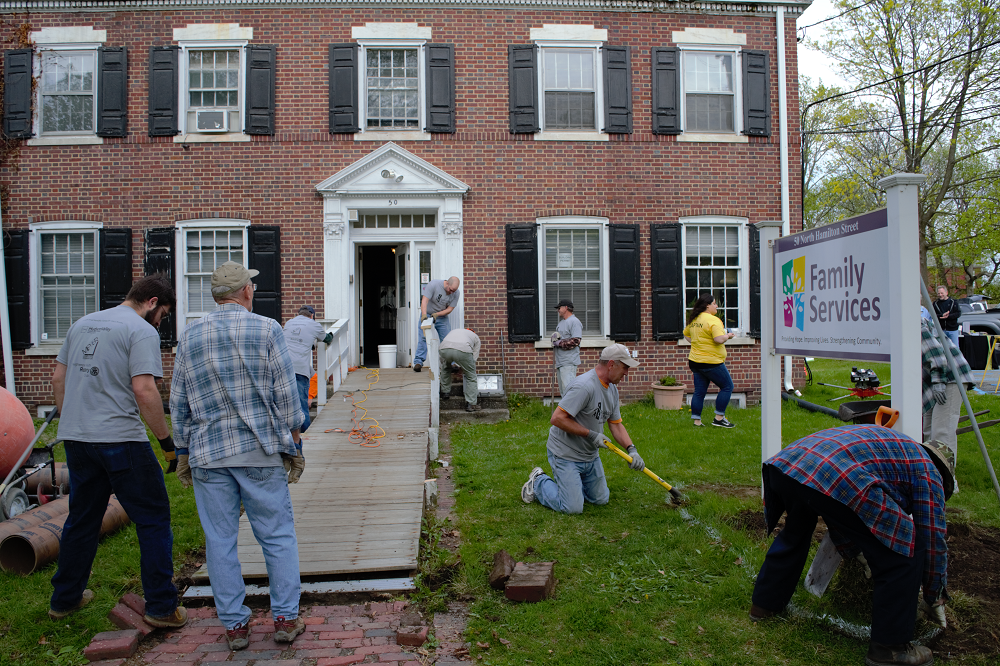 A team of HVCU volunteers remove an old accessibility ramp in preparation for it to be replaced as part of an RTDC Community Strong project.