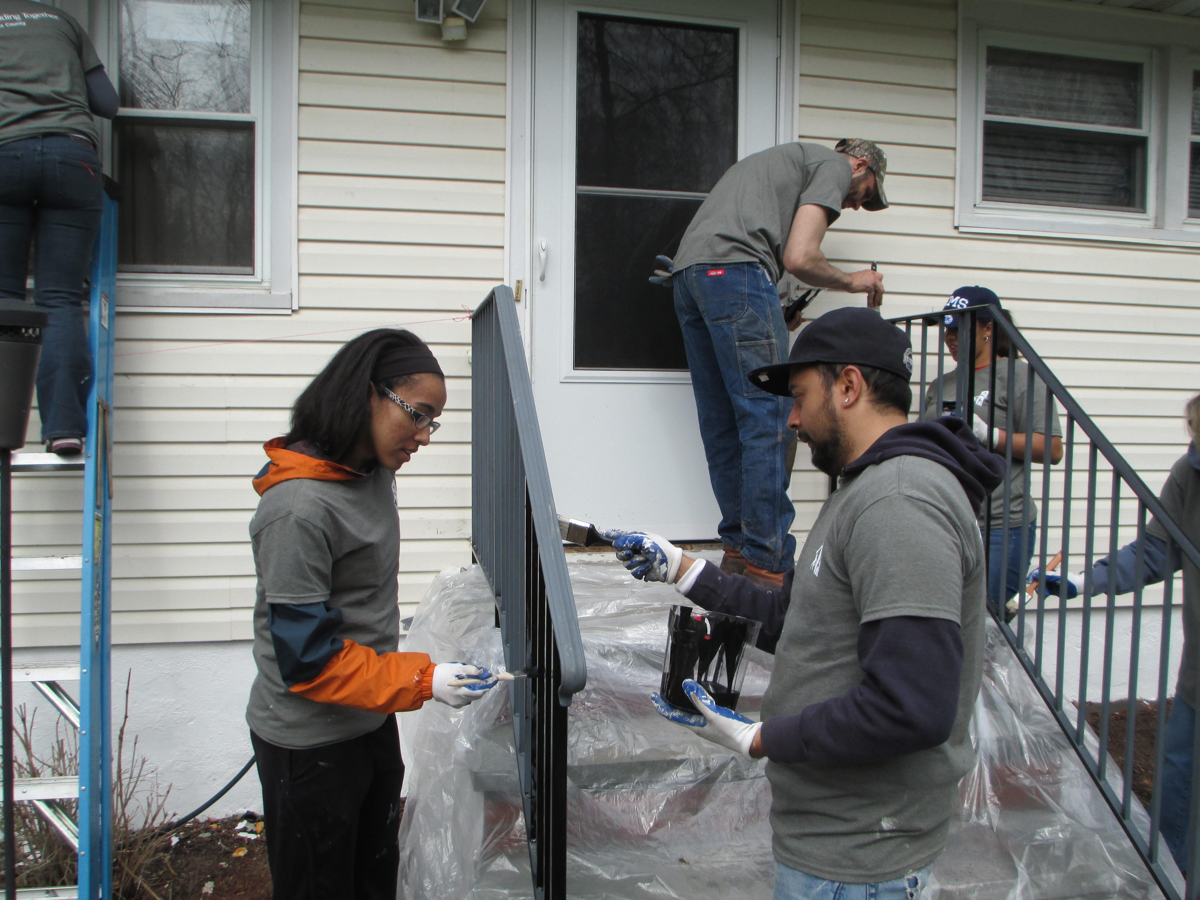 HVCU volunteers fix up the front porch railing for Kim in Poughkeepsie as part of a Rebuilding Day project in 2014.