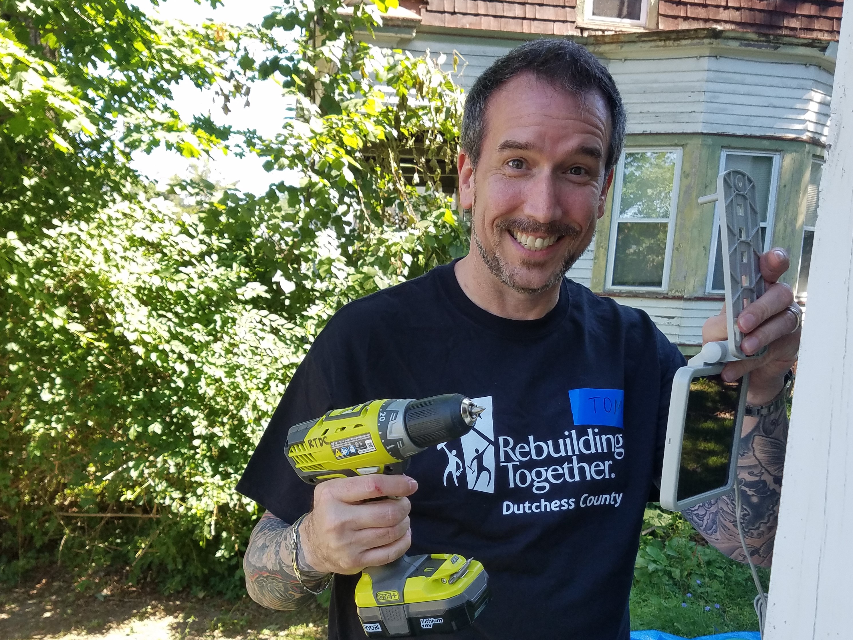 A State Farm volunteer installs a motion-activated solar light