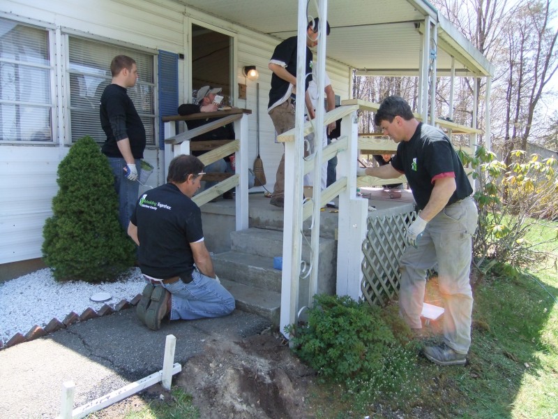 TD Bank volunteers working on a homeowner's porch